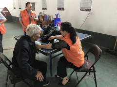 雄鹰村志愿者给老年人测血压