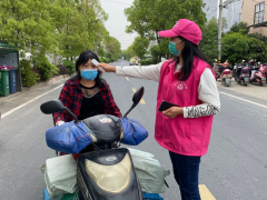 志愿者路口为过往行人测温，宣传疫情